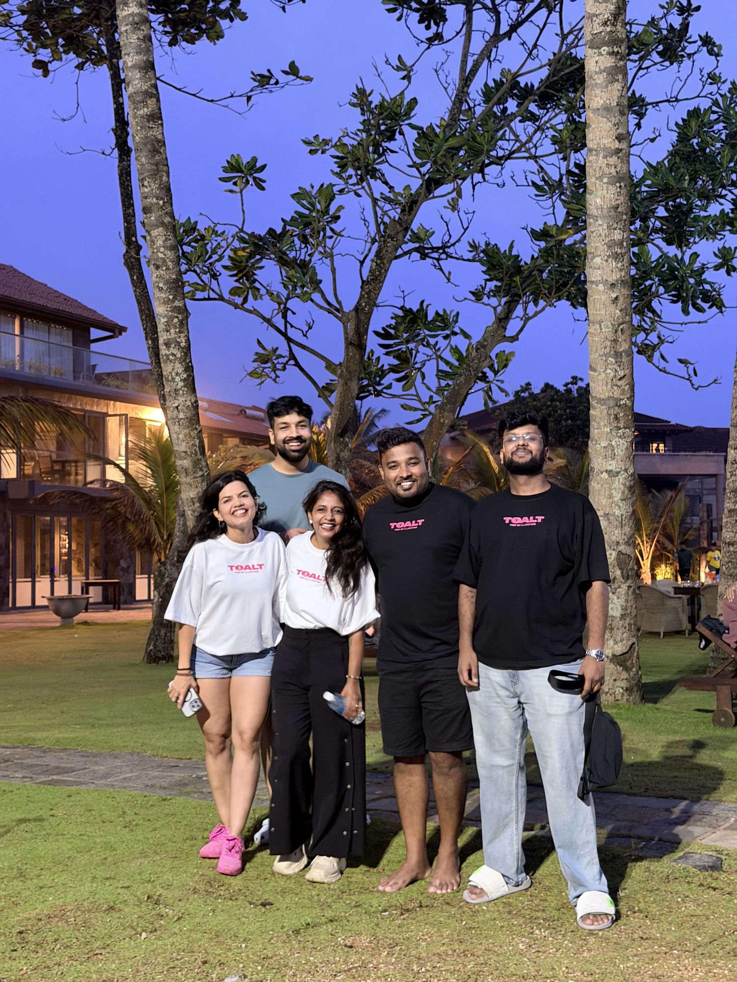 The TOALT crew in matching tees at dusk on a group trip