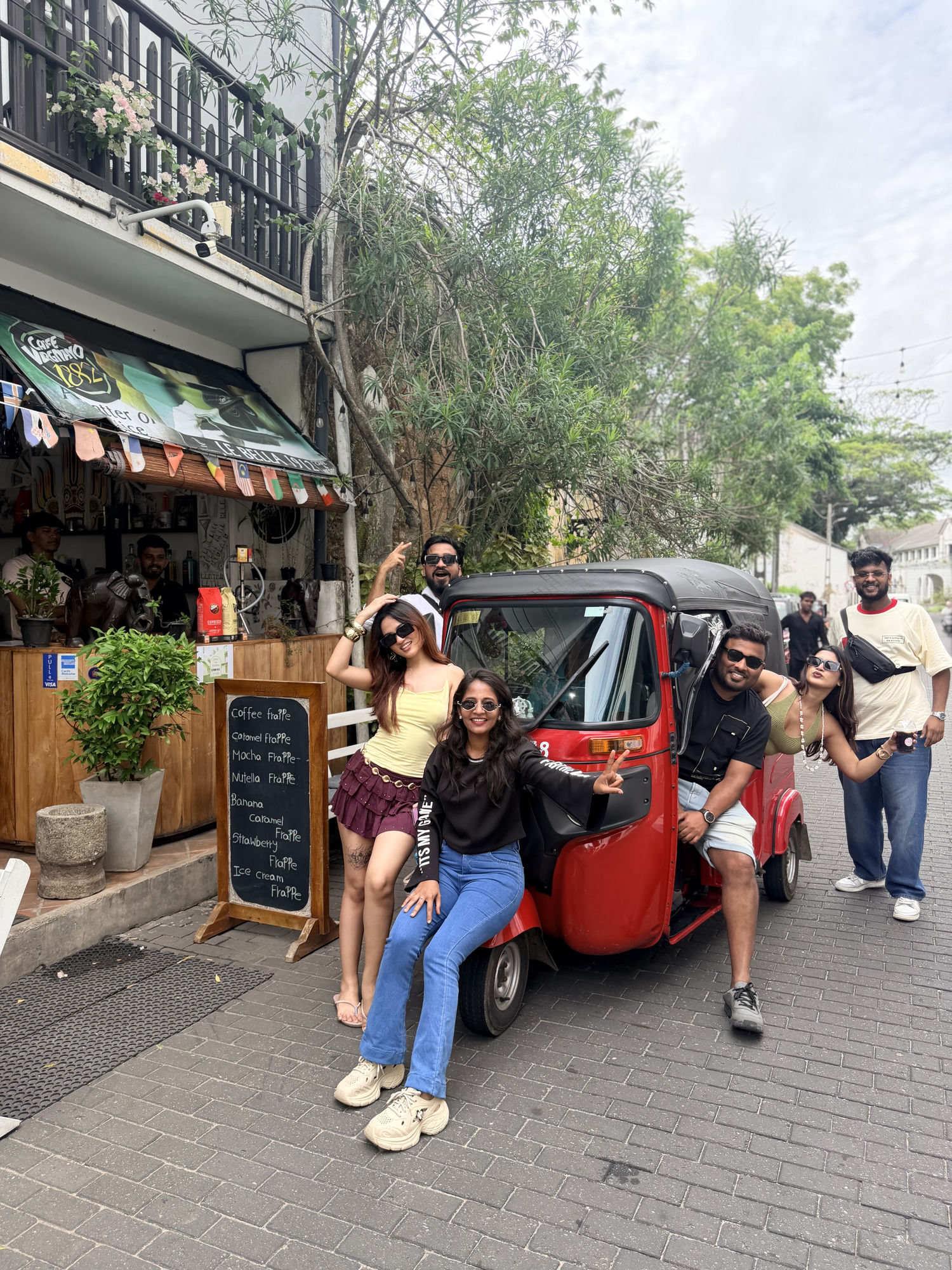 The TOALT crew posing with a tuk-tuk outside a café on a group trip