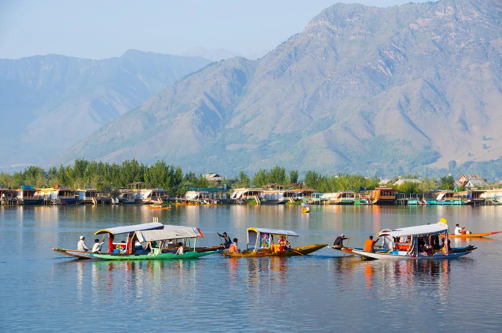 Snow-capped Kashmir mountains reflecting in a calm valley lake during early summer