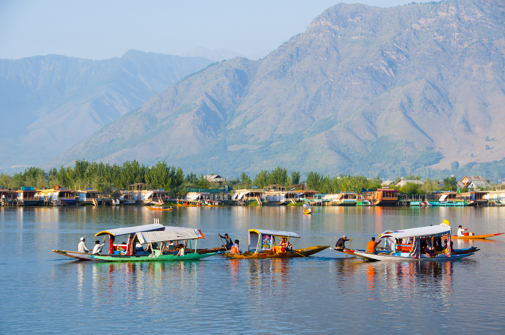 Snow-capped Kashmir mountains reflecting in a calm valley lake during early summer